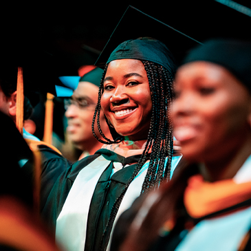 A graduate student smiles during the 10 a.m. Graduate ceremonies